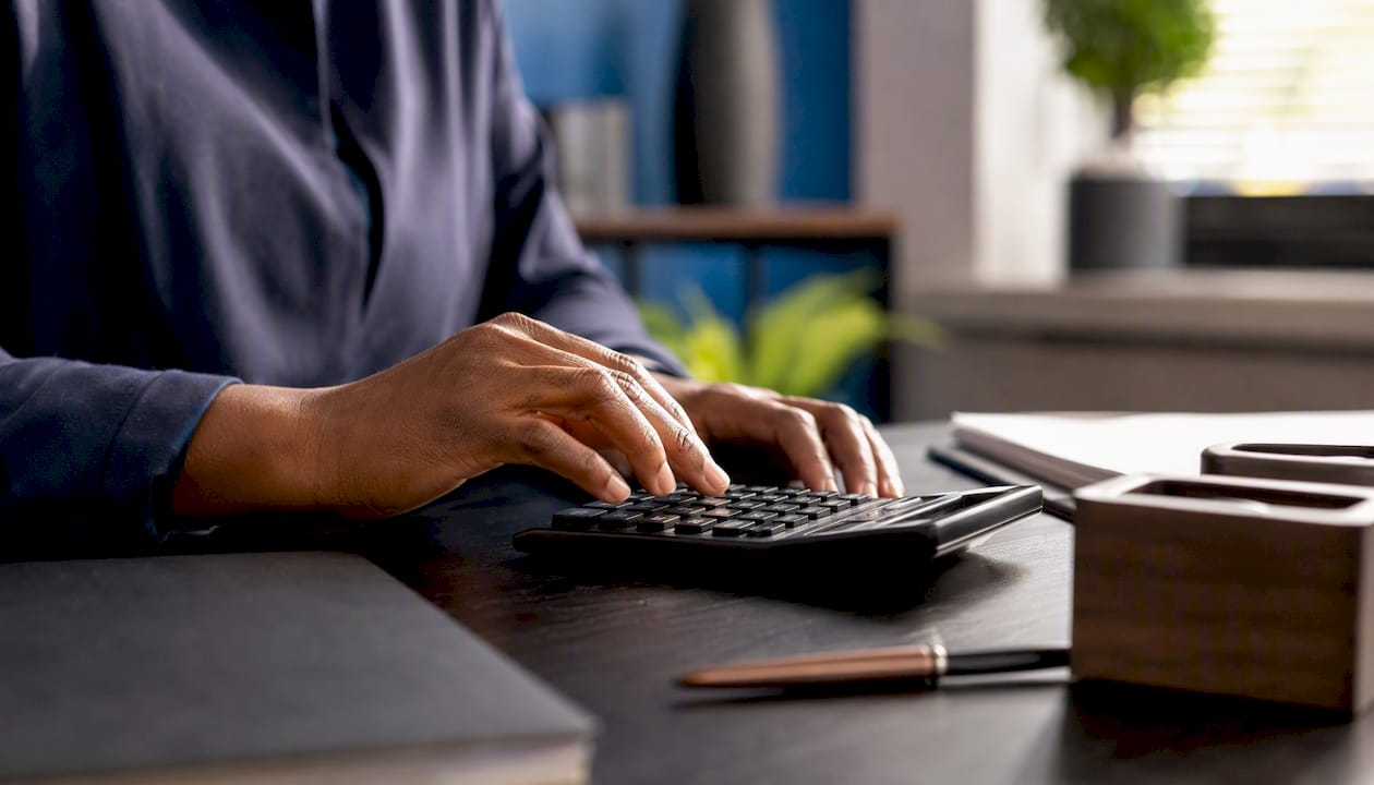 Hands calculating payroll adjustment on calculator