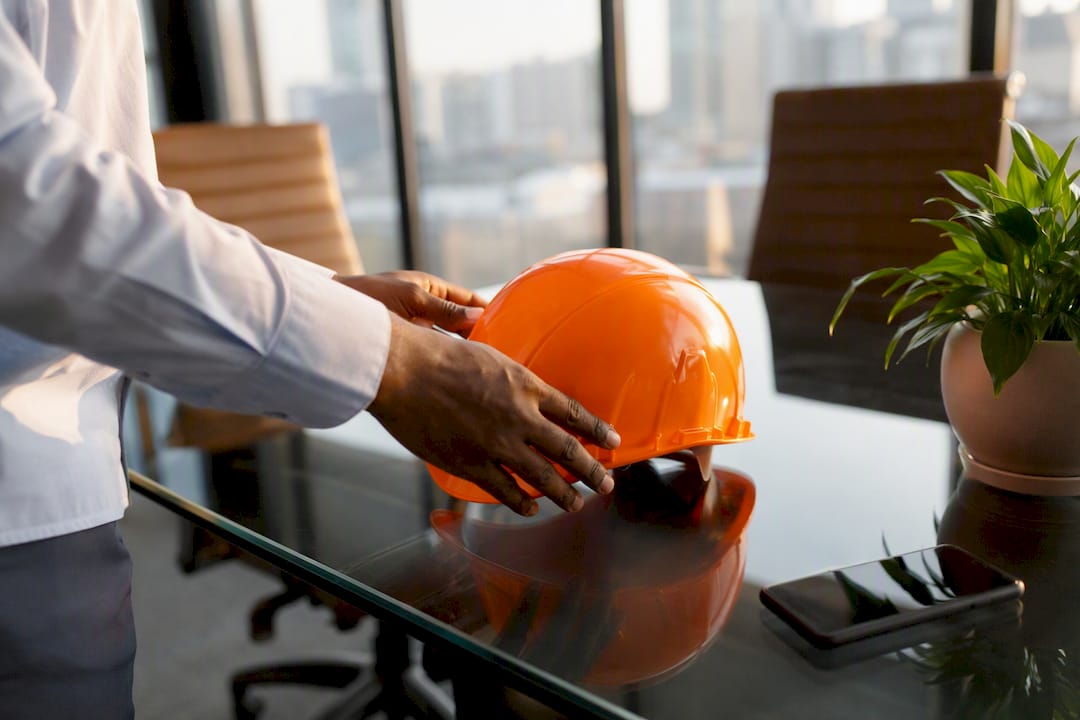 Hands placing safety helmet on office desk